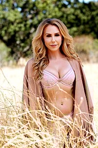 Holly Randall poses naked outdoors, displaying her small boobs and aroused nipples