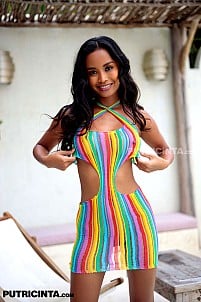 Putri Cinta poses temptingly in a rainbow-colored dress, radiating playful charm